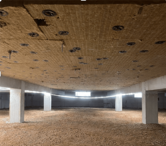Isolation thermique du plafond d'un vide sanitaire Isolation thermique du plafond d'un vide sanitaire avec panneaux isolants, piliers béton et éclairage LED.